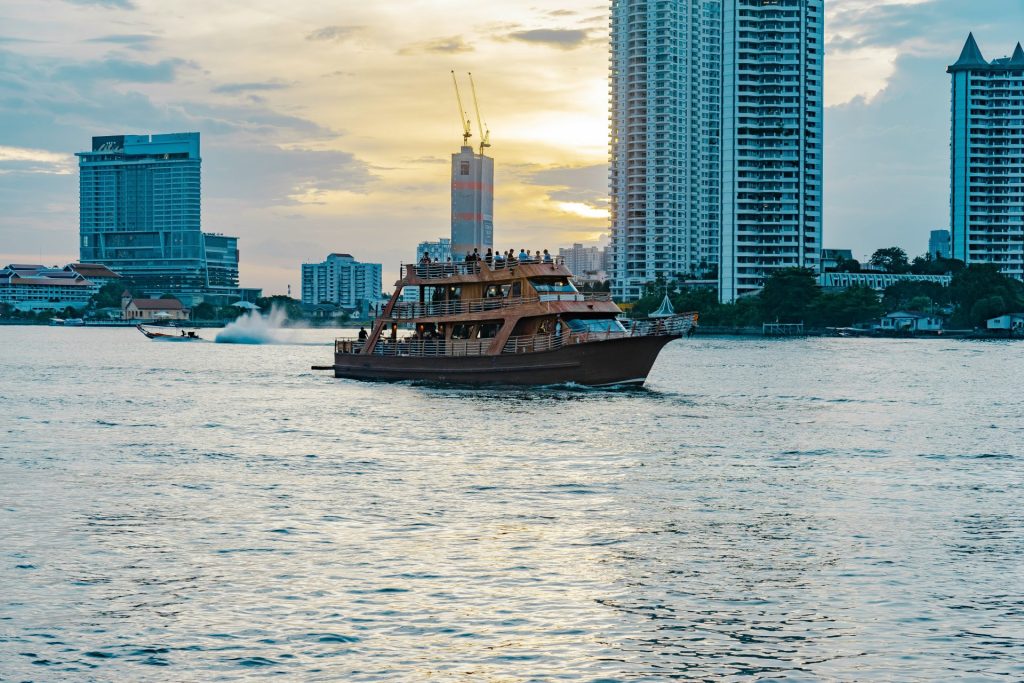 a boat traveling through the water in front of tall buildings
